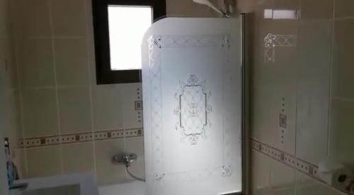 een badkamer met een douche, een raam en een wastafel bij Departamentos Márquez in Mar del Plata