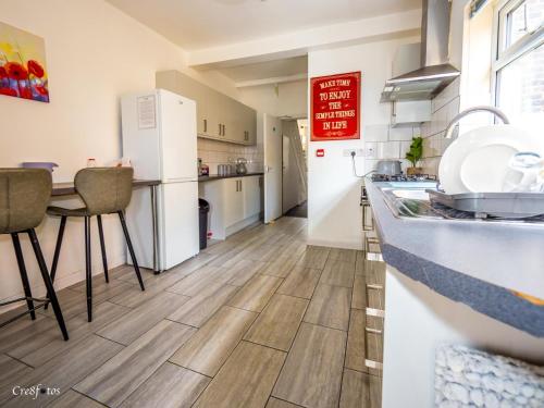 a kitchen with a counter and a table and a refrigerator at En-suite 1 Woodhouse, private bath, 2 kitchen in Stoke on Trent