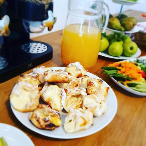 a plate of shrimp on a table with a glass of orange juice at Apartmán NeKLID - Rezidence K Lanovce in Jáchymov