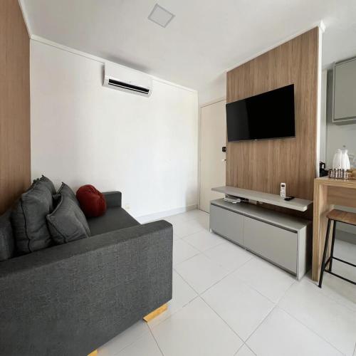 un salon avec un canapé et une télévision à écran plat dans l'établissement Metropolitan Barcelona Flamboyant Autódromo Serra Dourada Aeroporto 6 hospedes 2 garagens 3 ares condicionados, à Goiânia