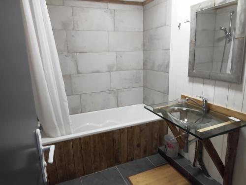 a bathroom with a bath tub and a sink at Maisonnée au cœur de la Thierache 