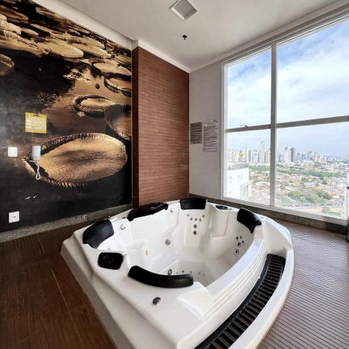 une baignoire dans une pièce avec une grande fenêtre dans l'établissement Metropolitan Barcelona Flamboyant Autódromo Serra Dourada Aeroporto 6 hospedes 2 garagens 3 ares condicionados, à Goiânia