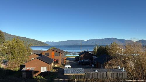a small town with a lake in the background at Cabañas dunn in Puerto Cisnes