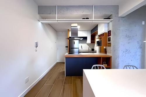 a kitchen with white walls and a blue counter top at Apto Design Moderno no Centro in Florianópolis