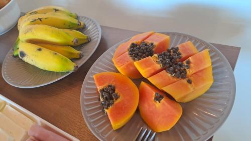 twee borden met papaja en een tros bananen bij Pousada Contemplar Tiradentes in Tiradentes