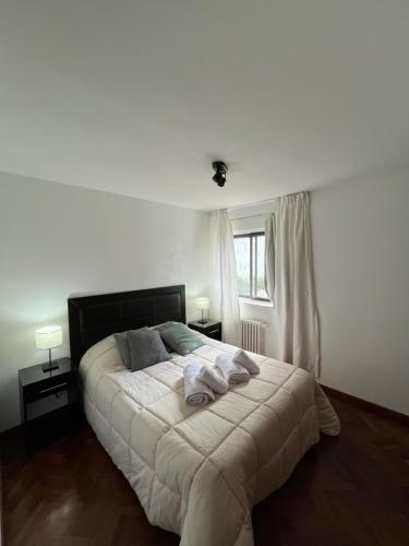 a bedroom with a bed with two towels on it at Departamento Costa del Lago Bariloche in San Carlos de Bariloche