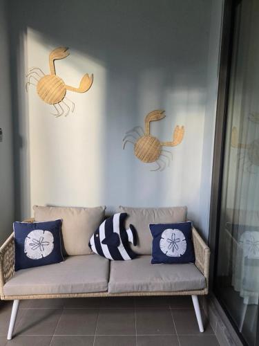 a couch in a living room with three ducks on the wall at La Residence Apartment 23 3 bedroom Pool Gym across the beach in Pereybere