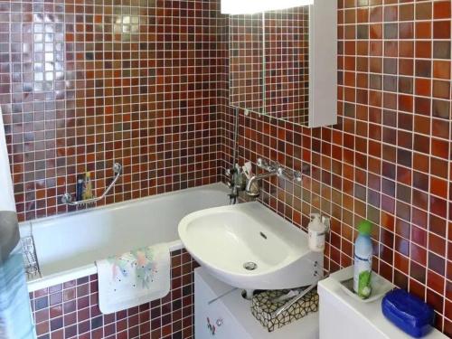 une salle de bain avec un lavabo et une baignoire dans l'établissement Ferienwohnung Aragon M88, à Ernen