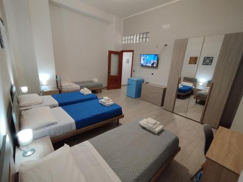 een hotelkamer met twee bedden en een woonkamer bij GiGi Affittacamere in Siracusa