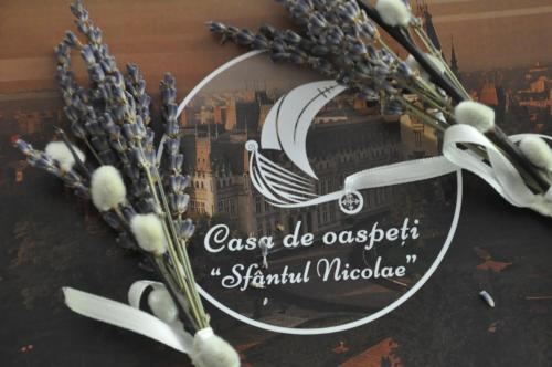 a sign with a picture of a ship and flowers at Casa de Oaspeți Sfântul Nicolae in Iaşi