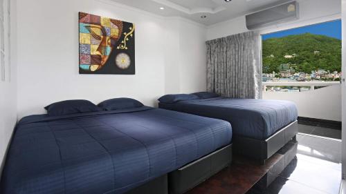 パトンビーチにあるPATONG TOWER FAMILY's APARTMENTS 2026の窓のある部屋にベッドが2つある