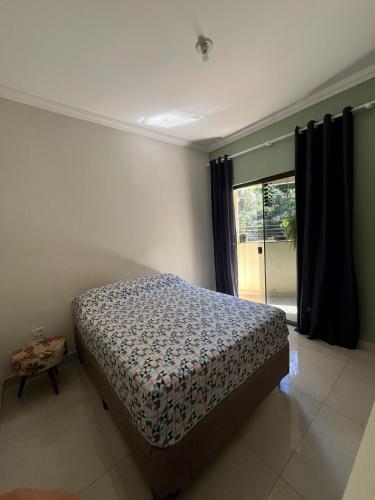 une chambre avec un lit et une grande fenêtre dans l'établissement Apartamento completo, central AP Cerrado Mineiro, à Araxá