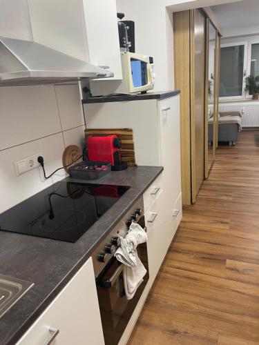 a kitchen with white cabinets and a black counter top at Helles Studio mit Terrasse nahe Therme und Park in Bad Säckingen