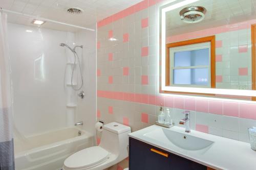 Un baño con inodoro, lavabo y espejo. en Comfortable Lincoln Home Walk to Main Street!, en Lincoln