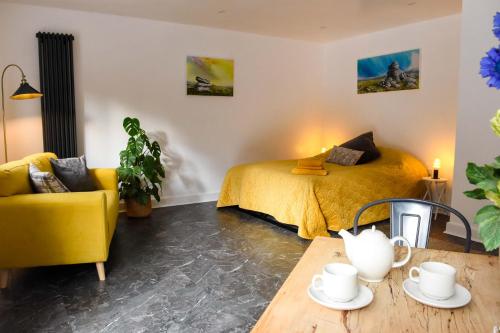 a bedroom with a yellow bed and a table at Badgers Holt House in Plymouth