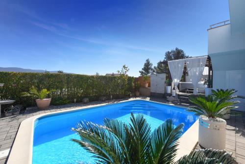 a swimming pool in the backyard of a house at My Dalmatia - Sea view Villa Bella with private heated pool and jacuzzi in Kokić