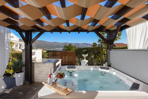 a hot tub on the patio of a house at My Dalmatia - Sea view Villa Bella with private heated pool and jacuzzi in Kokić