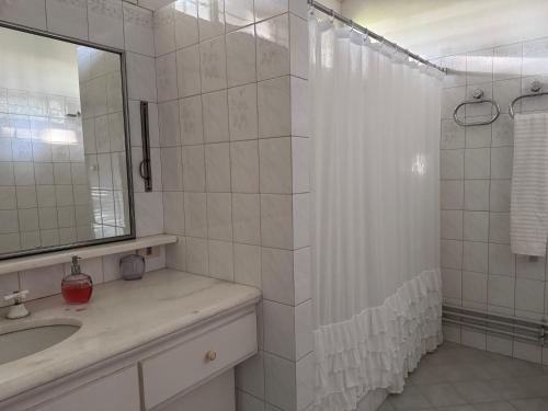 une salle de bains avec douche, lavabo et miroir dans l'établissement El Caburé - Casa de Campo, à Young