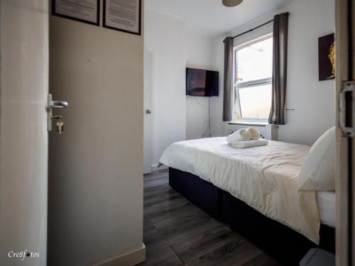 Un dormitorio pequeño con una cama y una ventana. en En-suite 3 Woodhouse, private bath, 2 kitchen, en Stoke on Trent
