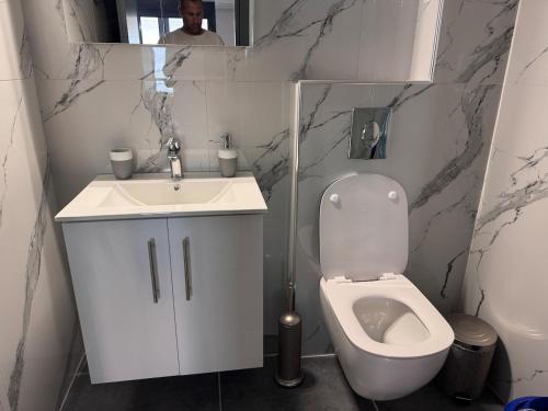 a bathroom with a white toilet and a sink at EmmeleiaLuxuryStudio in Xanthi