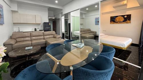 a living room with a glass table and blue chairs at PATONG TOWER APARTMENT's 2026 in Patong Beach