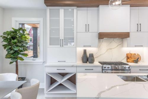 a kitchen with white cabinets and a stove at Prestige 3BR Luxury Living in Queen West in Toronto