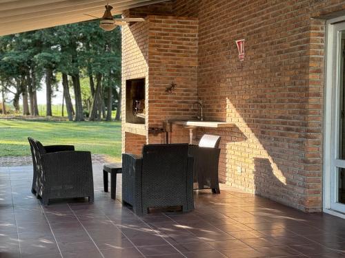 d'une terrasse avec des chaises, une table et un mur en briques. dans l'établissement El Caburé - Casa de Campo, à Young