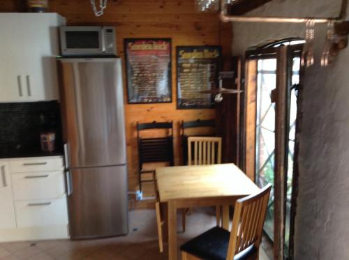 a kitchen with a wooden table and a refrigerator at Lusthuset in Sölvesborg