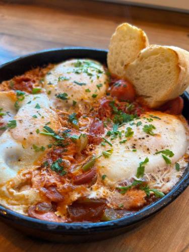 un plato de comida con huevos y pan en una mesa en Wellotel Chornomorsk, en Chornomorsk