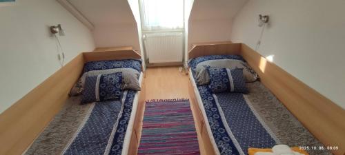een kamer met 2 bedden in een kleine kamer bij Magyar Tenger Pihenőház, 4-8 főre Balatonakarattya in Balatonakarattya