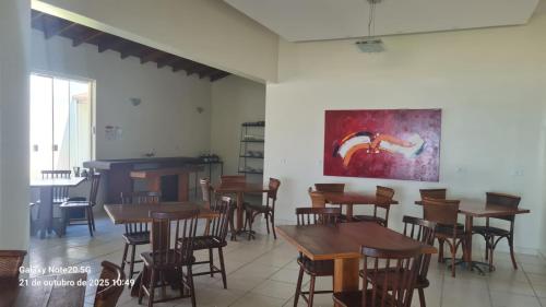 a room with tables and chairs and a painting on the wall at Pousada Areia e Mar in Ubatuba