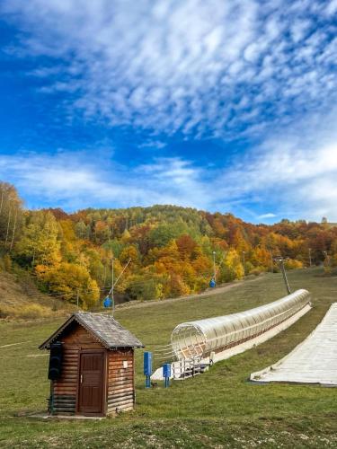 un fienile e un lungo tubo in un campo di Hotel Junior a Kopaonik