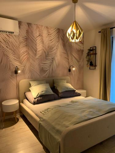 Un dormitorio con una cama grande con una lámpara de araña. en Relax Apartman Siófok, en Siófok