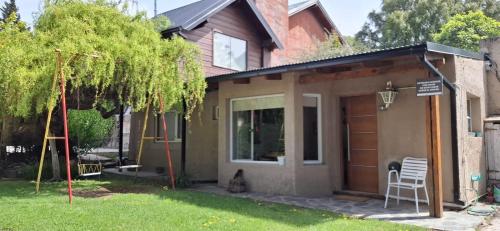 a cat sitting in front of a house at La Fontana Cabañas in San Carlos de Bariloche