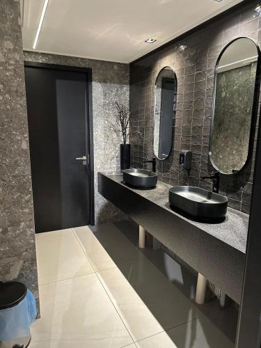 um banheiro com duas pias e dois espelhos em Move Tambau 108 em Tambaú