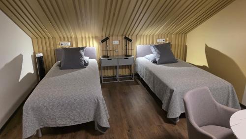 a room with two beds and a table and chairs at good mood guesthouse in Otepää