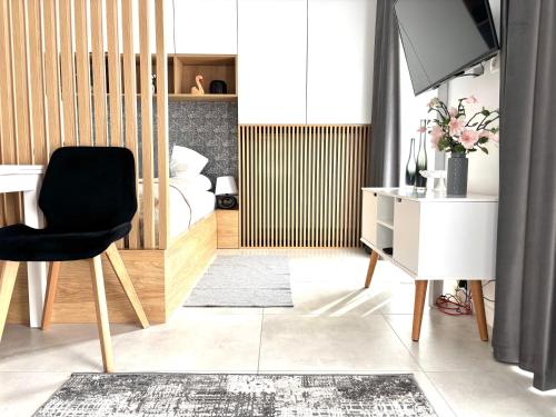 sala de estar con silla negra y TV en EASY RENT- Business Center 194 Free Parking 24h Check-in, en Lublin