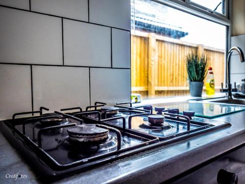 a stove top oven in a kitchen next to a sink at En-suite 4 Woodhouse, private bath, 2 kitchen in Stoke on Trent