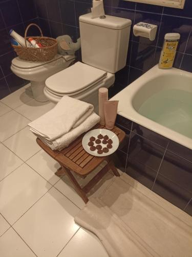 a bathroom with a toilet and a bath tub with towels at apartamento céntrico zona Marques de comillas 8 in Laredo