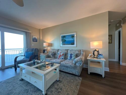 a living room with a couch and a table at Beachfront Condo, Ocean Views, Near Patrick SFB in Satellite Beach