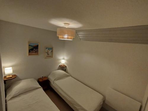 a room with two beds and two lights on the wall at Alt'à Luz, Duplex 2 étoiles, 4 Pers , Ménage inclus in Luz-Saint-Sauveur