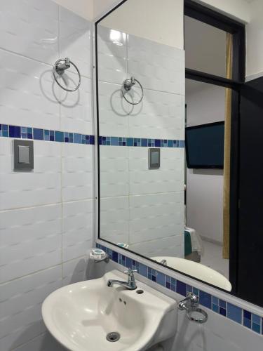 a bathroom with a sink and a mirror at Hotel Rodasuites in Santa Marta