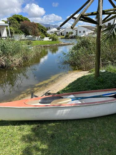 a boat sitting on the grass next to a river at Bella Vista Lago in Marina da Gama