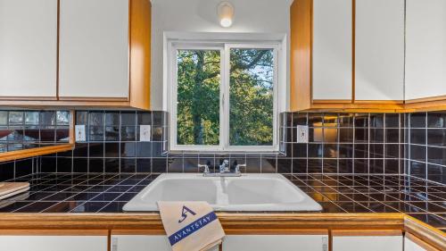 a kitchen with a sink and a window at Incredible Water Views Deck Relaxing Retreat Greenbank Getaway by AvantStay in Greenbank