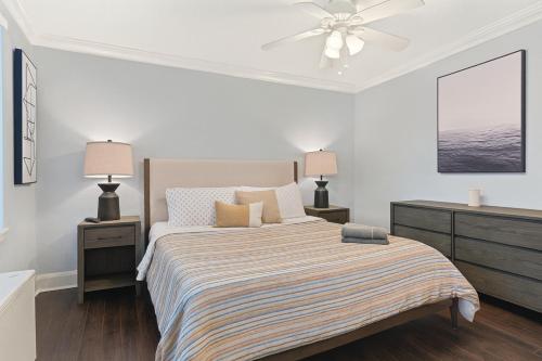 ein weißes Schlafzimmer mit einem Bett und zwei Nachttischen in der Unterkunft Downtown 1br Condo Walk To Stadium & Aquarium in Atlanta