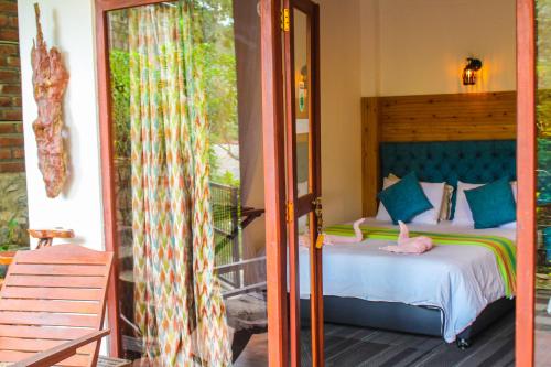 een slaapkamer met een bed en een glazen schuifdeur bij Ella Mc Queen Homestay in Ella