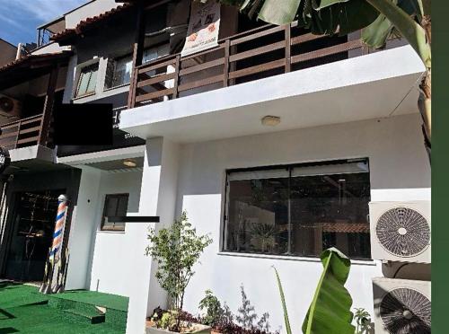 een wit huis met een raam en een groene tuin bij House Bela Vista in Porto Alegre