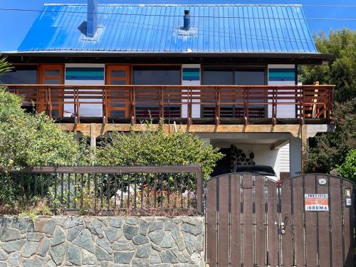 una casa con una valla de madera delante de ella en Refugio Guanay, en Constitución
