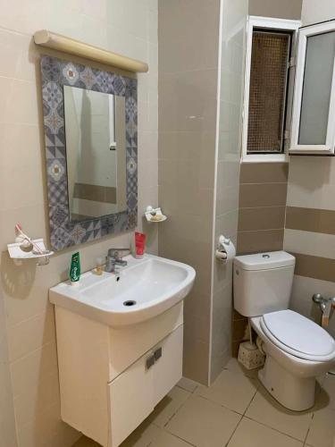 un bagno con lavandino, WC e specchio di Zen apartment a Tunisi