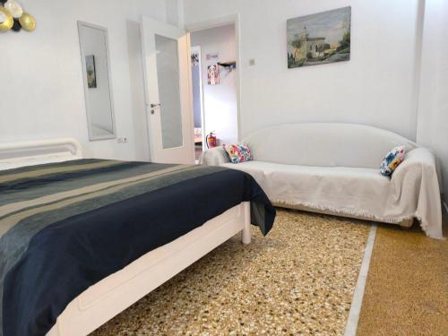 Un dormitorio con una cama y un sofá. en Katerina's Family House, en Chalkida